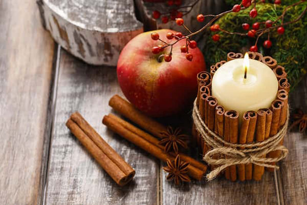 Candle stick with cinnamon sticks around to make a diy gift for mom for christmas