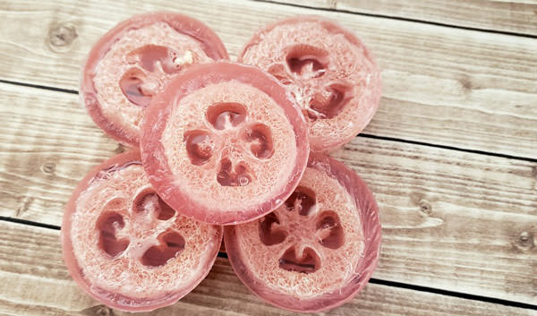 pink loofah soaps on wood table
