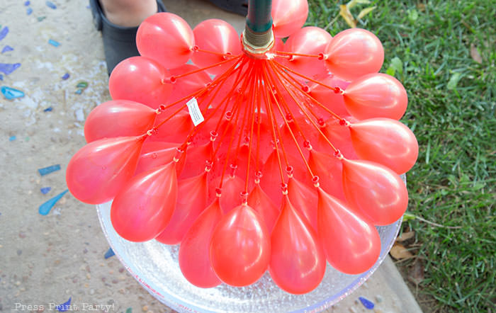 Filling up water balloon fast with bunch o balloons. red water balloons for water balloon games for kids. Press Print Party