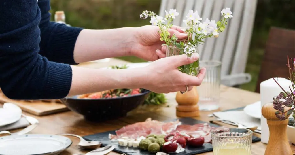 Woman setting dinner table - 15 fancy appetizers quick easy party appetizer ideas - Press Print Party!