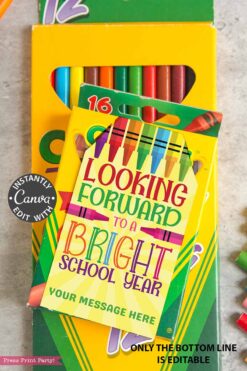 The Back to School Teacher Gift Tags Printable features a vibrant “Looking forward to a bright school year” card on a box of crayons, with space below for your custom message. Several crayons and part of the green crayon box appear in the background.