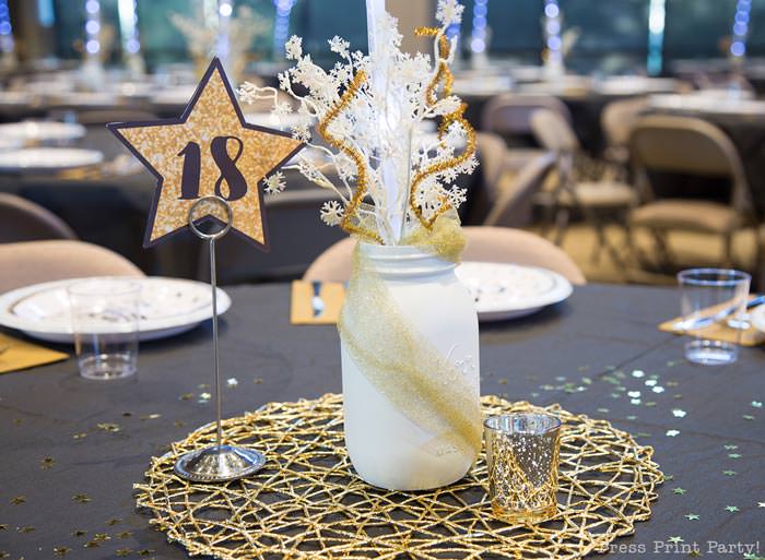 How to set up a sparkling christmas banquet with LED Bobo balloons with string lights. Press Print Party! Christmas table centerpiece with mason jar, snow spray, table number in star shape and golden placemat on black tablecloth.