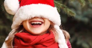 50 actually funny christmas jokes for kids - laughing girl with santa hat - Press Print Party!