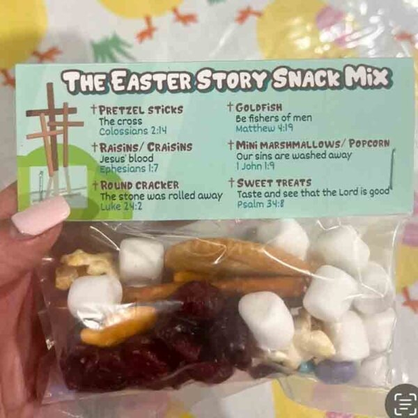 A hand holds a colorful bag labeled "I ❤ Our Friend-chip," containing pretzel sticks, raisins, round crackers, goldfish crackers, mini marshmallows, and sweet treats. Each snack is connected to a biblical reference in Easter symbolism.