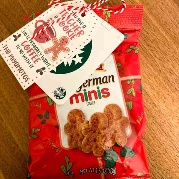 A red bag of German Minis cookies sits on a wooden surface, similar to a chip bag in its crisp allure. A festive tag with the Starbucks logo is attached, reading "I ❤ Our Friend-chip.
