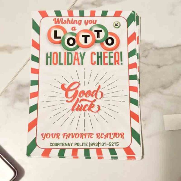 On the table lies a festive card with a green and red striped border reading: "Wishing you a Lotto Holiday Cheer! Good luck." Just like finding a surprise in an I ❤ Our Friend-chip bag, it ends with "Your Favorite Realtor," followed by their name and phone number.