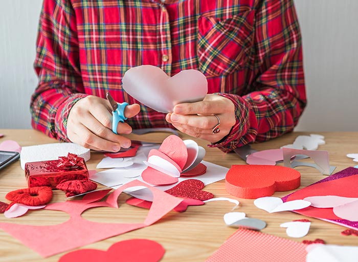 woman cutting hearts for Valentine's day crafts. Press Print Party!