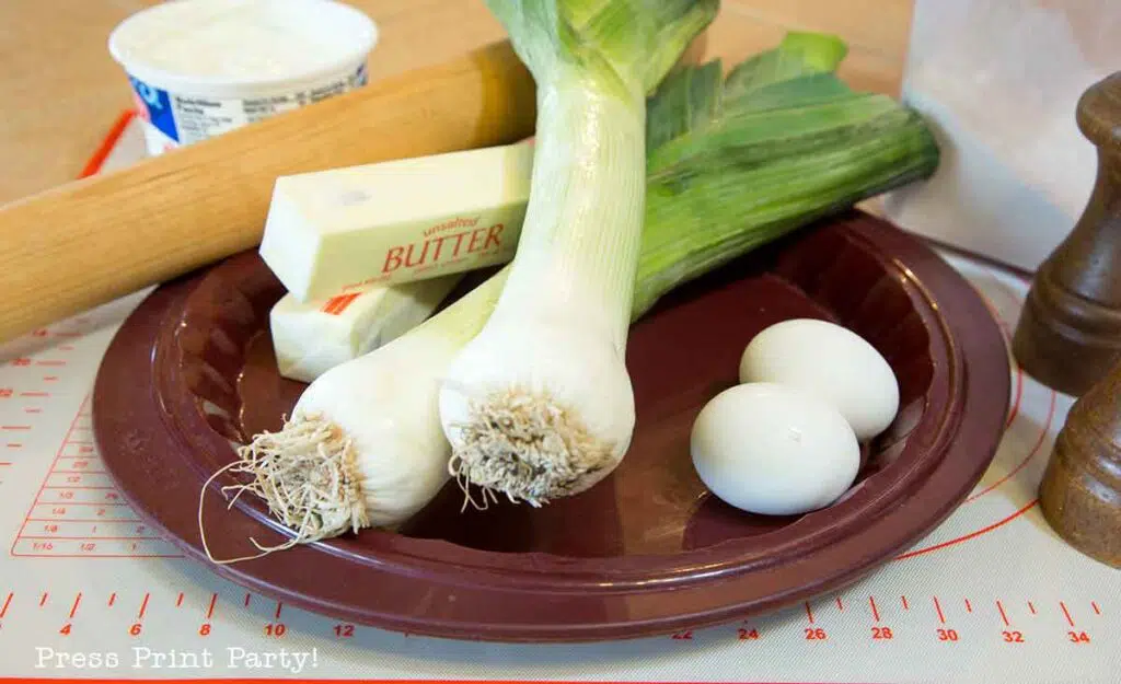 flamiche aux poireaux french leek tart. ingredients on counter- leek - eggs- butter. Press Print Party!