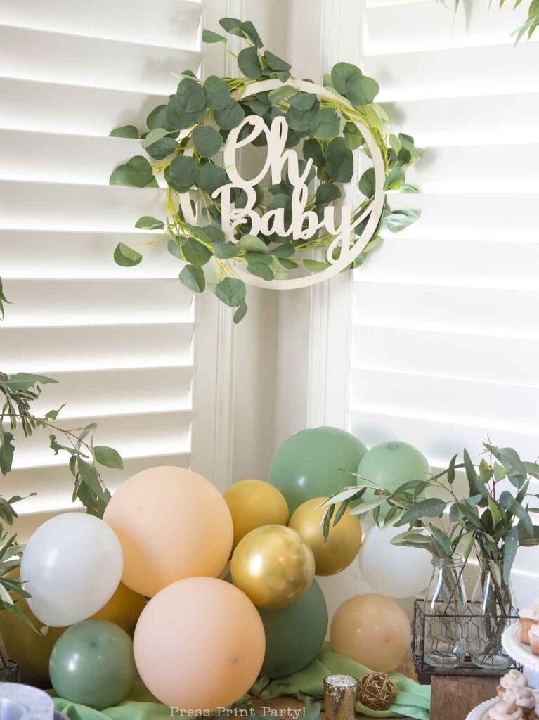 Greenery baby shower decor ideas with printable banner and eucalyptus on table and balloons peach and green and oh baby sign - Press Print Party!