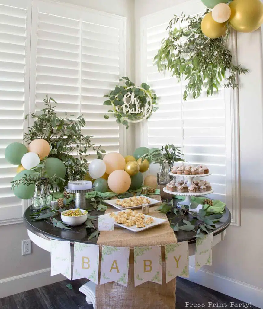 Greenery baby shower decor ideas with printable banner and eucalyptus on table and balloons peach and green and oh baby sign - Press Print Party!