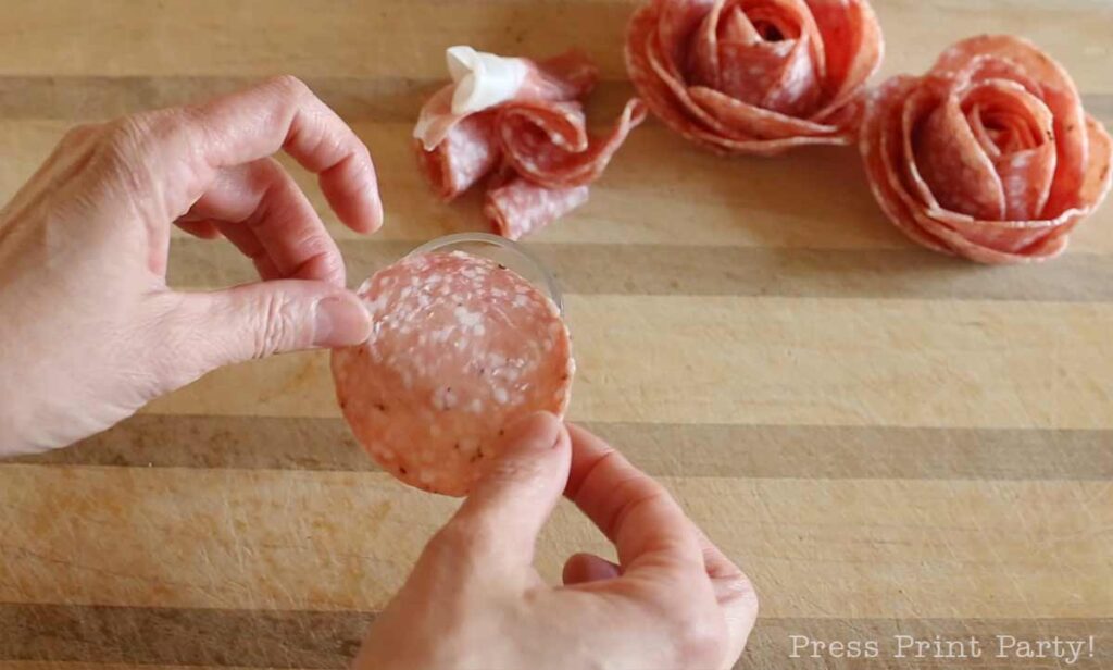 salami slice over shot glass -how to make a salami rose for your charcuterie board - Press Print Party