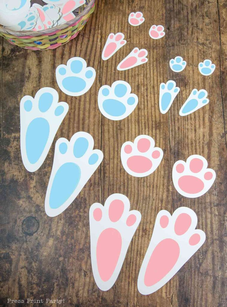 free printable easter bunny footprints and stencils in 2 sizes and 2 colors blue and pink. with Easter basket on brown floor - Press Print Party!
