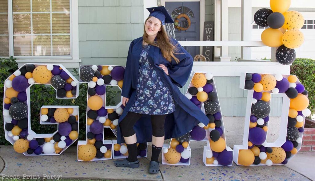 Balloon mosaic letters free template for graduation with girl graduate in front with black gold and purple balloons- Press Print Party!