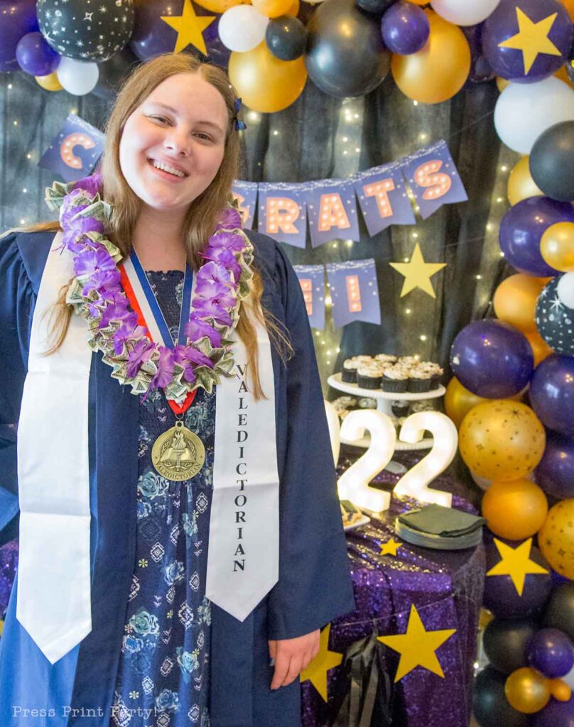 Girl with money lei at graduation party. How to Make a Money Graduation Lei Two Easy Ways - how to make graduation lei with money from a dollar store lei and with construction paper and ribbon - Press Print Party!