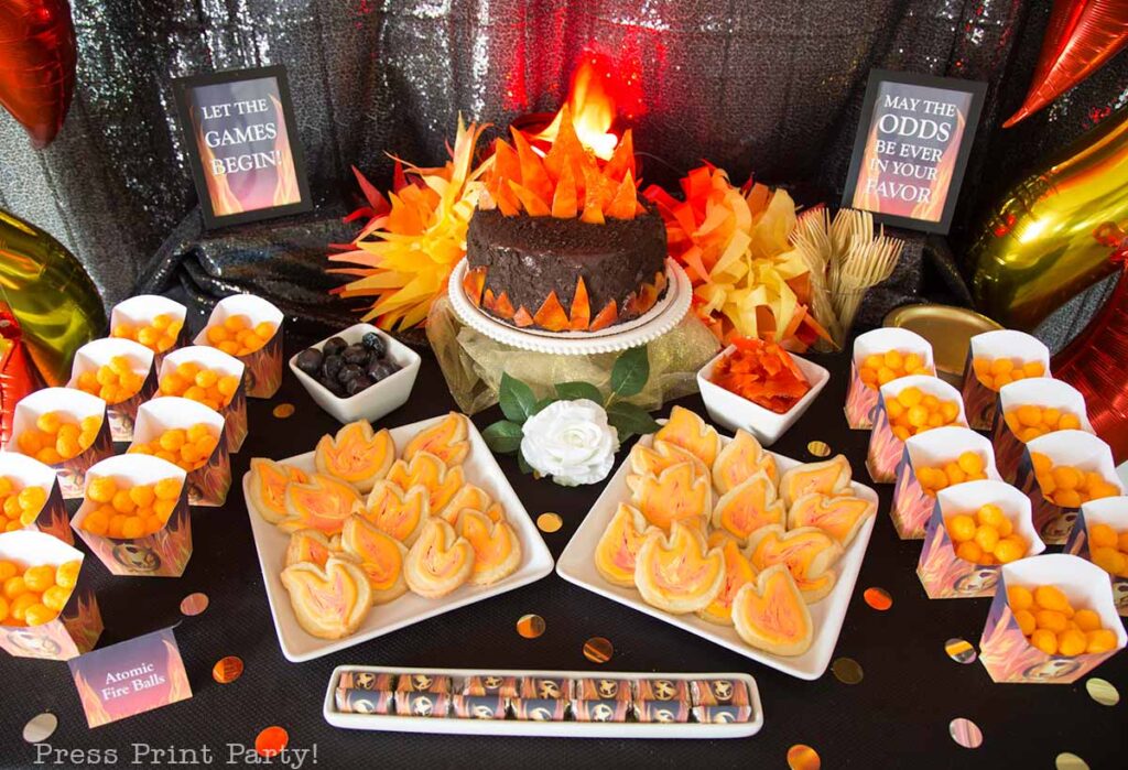 dessert table with coal on fire cake and flame cookies and fire balls hunger games printables- Our epic hunger games party for teens, hunger games party theme birthday party, food, decorations and games - Press Print Party
