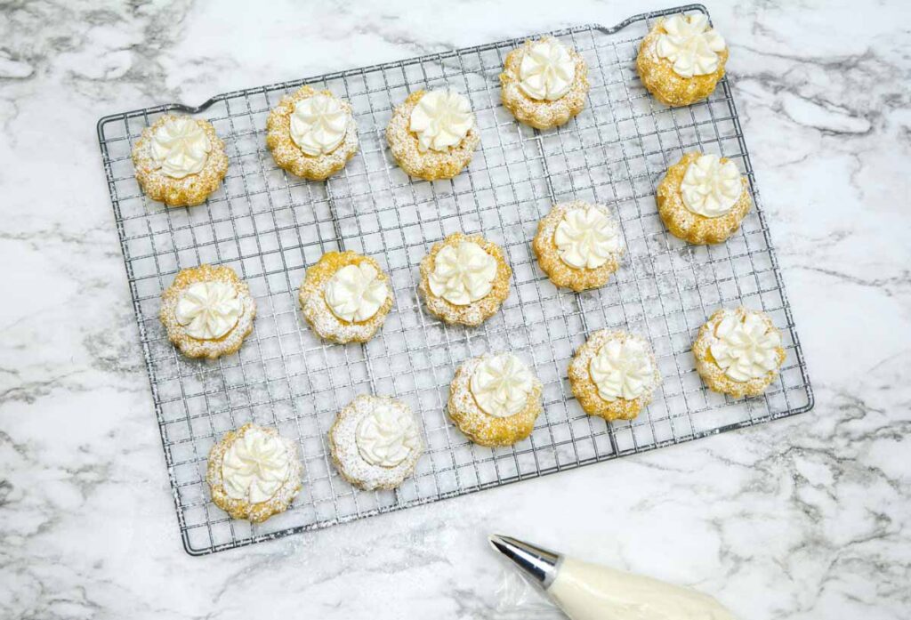 bundt cakes on wire rack -Best mini pumpkin bundt cake with cream cheese frosting recipe with powered sugar, delicious perfect fall dessert - Press Print Party!