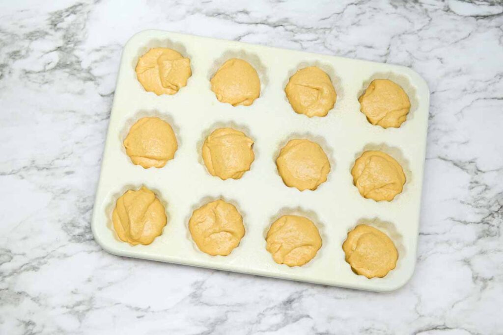 batter in the buntlet pan - Best mini pumpkin bundt cake with cream cheese frosting recipe with powered sugar, delicious perfect fall dessert - Press Print Party!