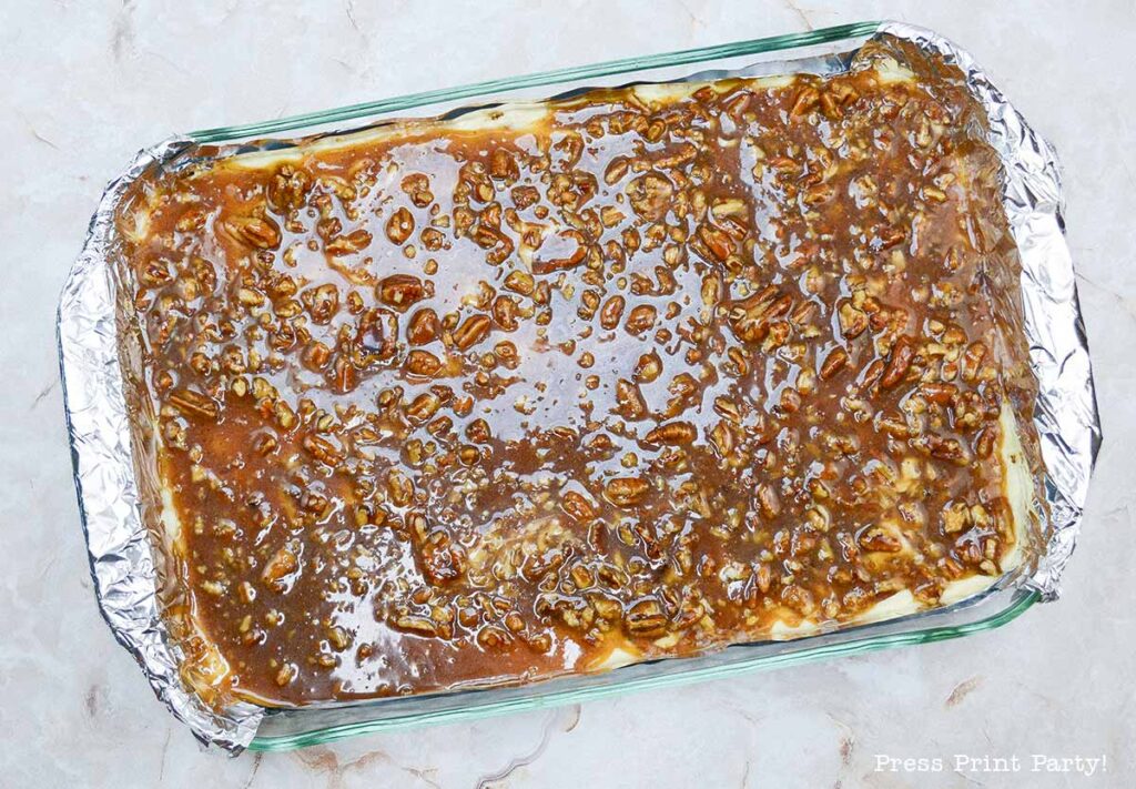 3rd layer with the pecans - easy pecan pie cheesecake bars recipe squares. graham cracker crust, cheesecake. caramel and pecans on top. great for thanksgiving fall recipe treat. Press Print Party!