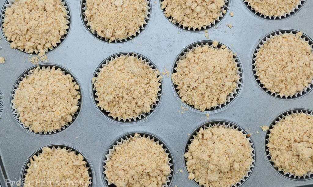 streusel crumbs on top of batter - pumpkin streusel muffins recipe with vanilla glaze. A great fall treat for thanksgiving dessert - Press Print Party!