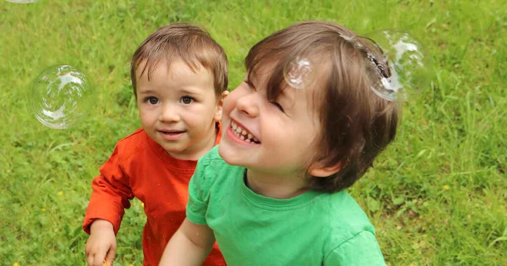 2 toddlers playing with bubbles - 15 fun birthday party activities for toddlers and young kids - Press Print Party!