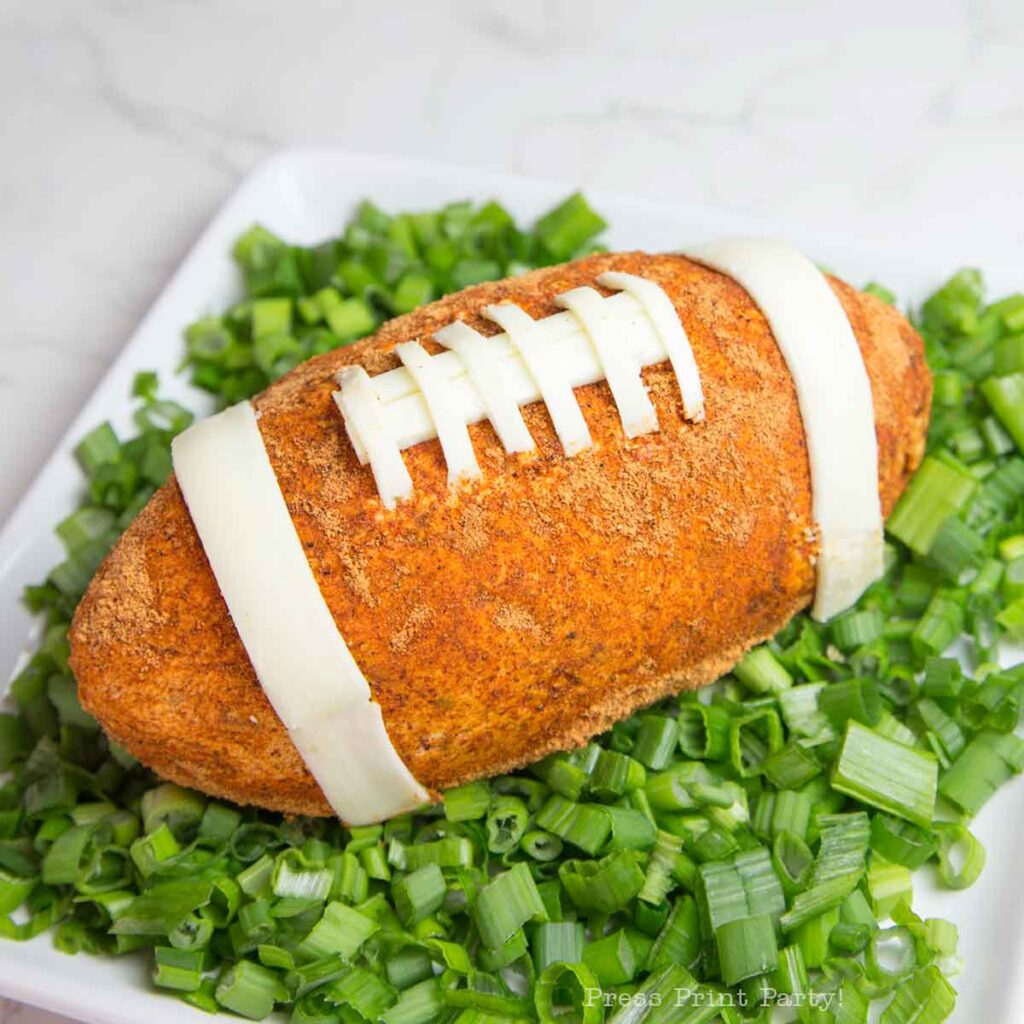 football cheese ball on bed of onions - football shaped cheese ball - cheese footballs - Press Print Party!