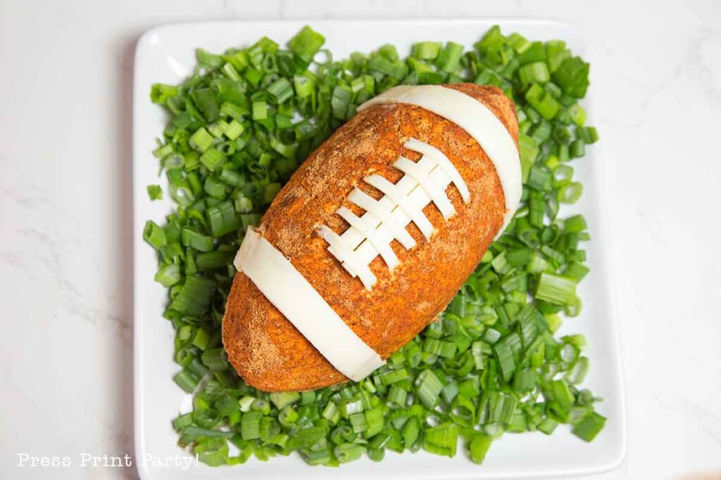 football cheese ball on bed of onions - football shaped cheese ball - cheese footballs - Press Print Party!