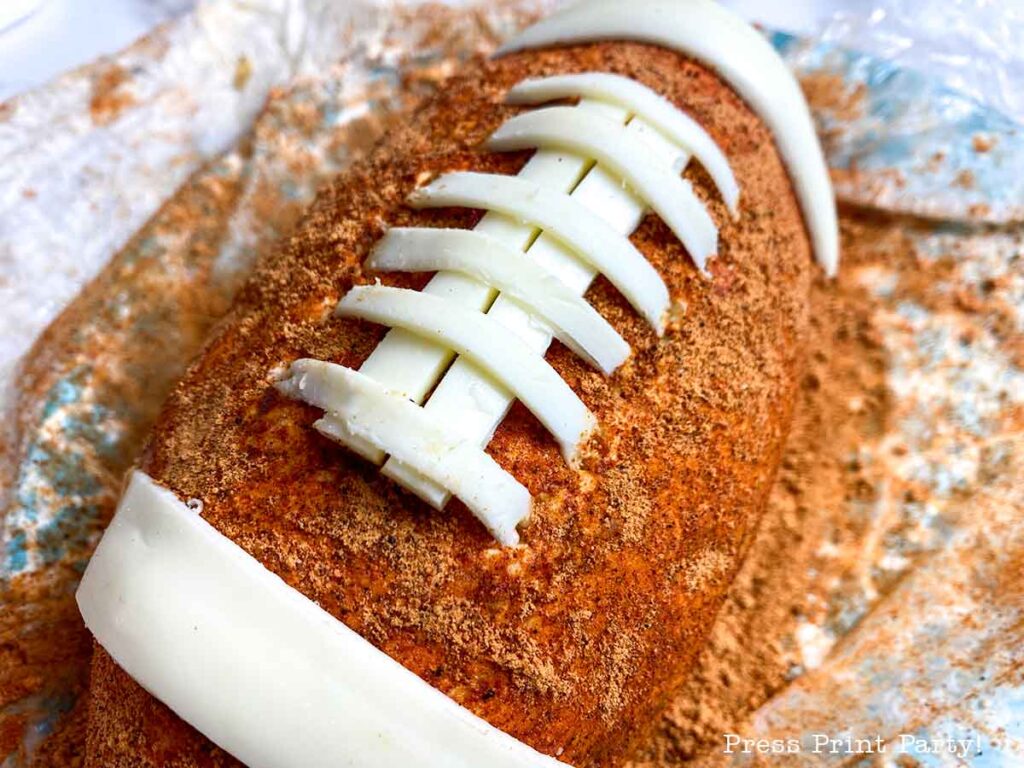 football cheese ball on bed of onions - football shaped cheese ball - cheese footballs - Press Print Party!