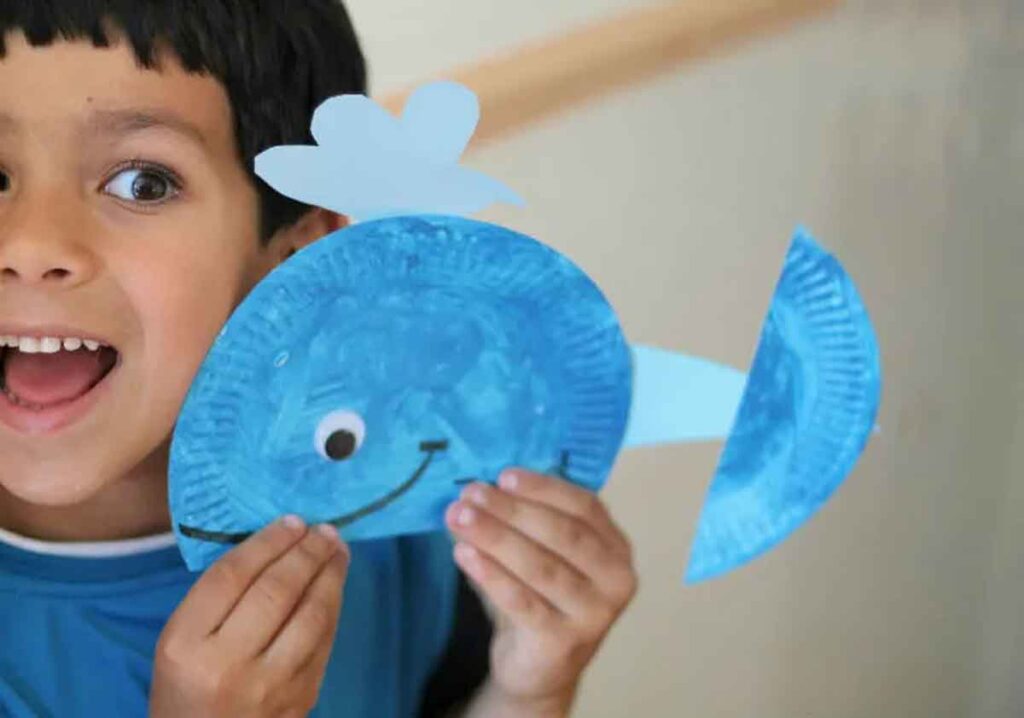 Paper Plate Whale by In the Playroom - kid holding the paper whale