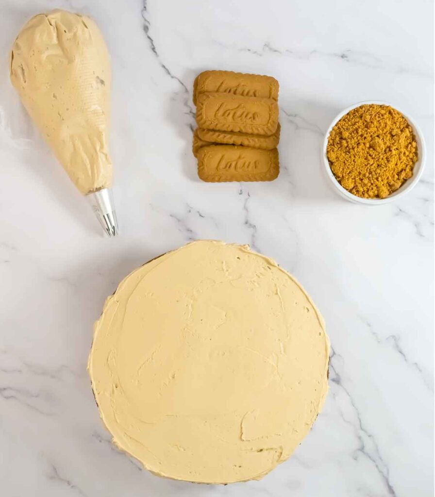 cake with buttercream rosette and biscoff cookies crumbled on the side