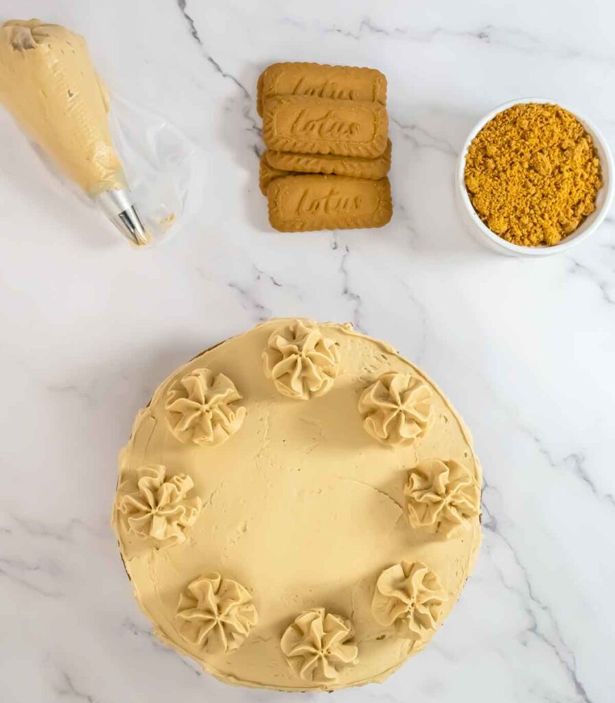 cake with buttercream rosette and biscoff cookies crumbled on the side