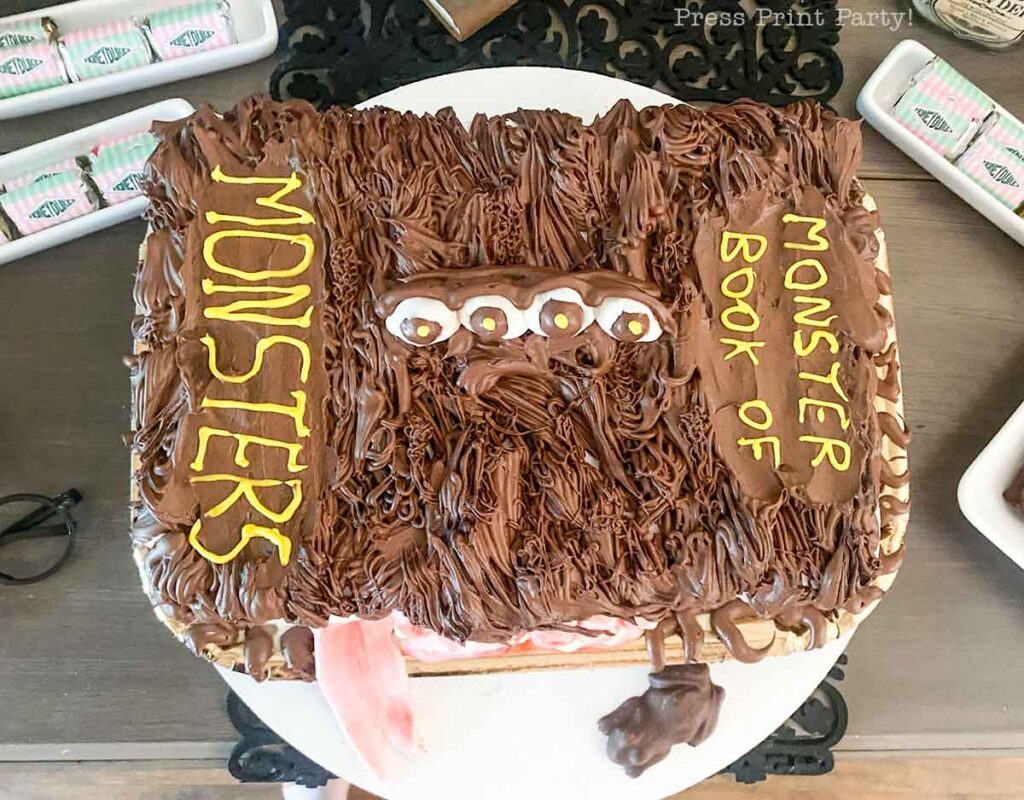 top of monster book of monsters cake on table with chocolate frog - Press Print Party