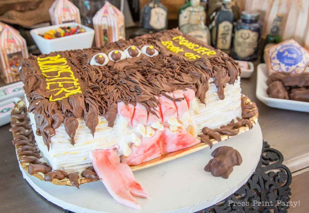 monster book of monsters cake on table with chocolate frog - Press Print Party