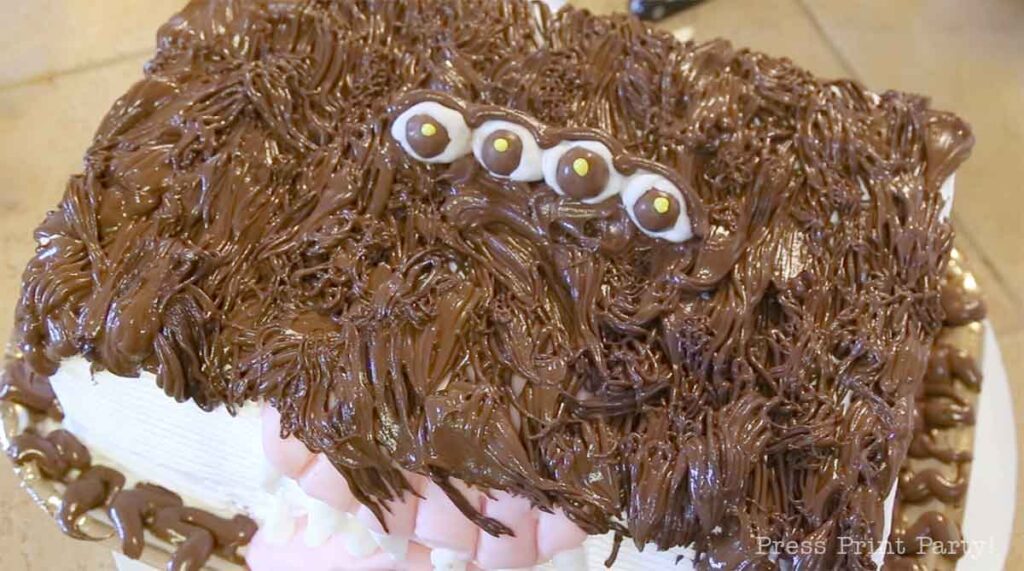 getting the chocolate buttercream fur on the monster book of monsters cake on table - Press Print