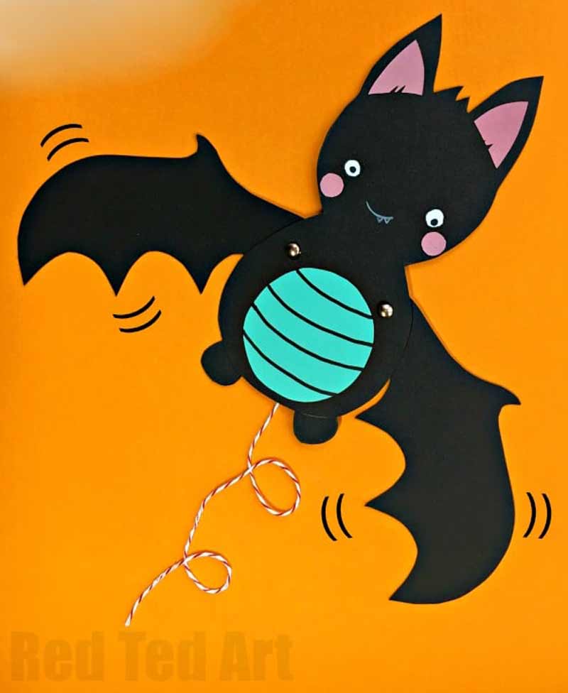 a paper bat with a blue ball and black wings