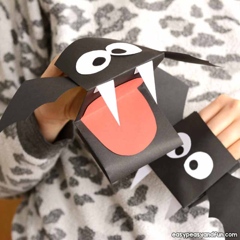 a person holding a paper bat puppet made with paper