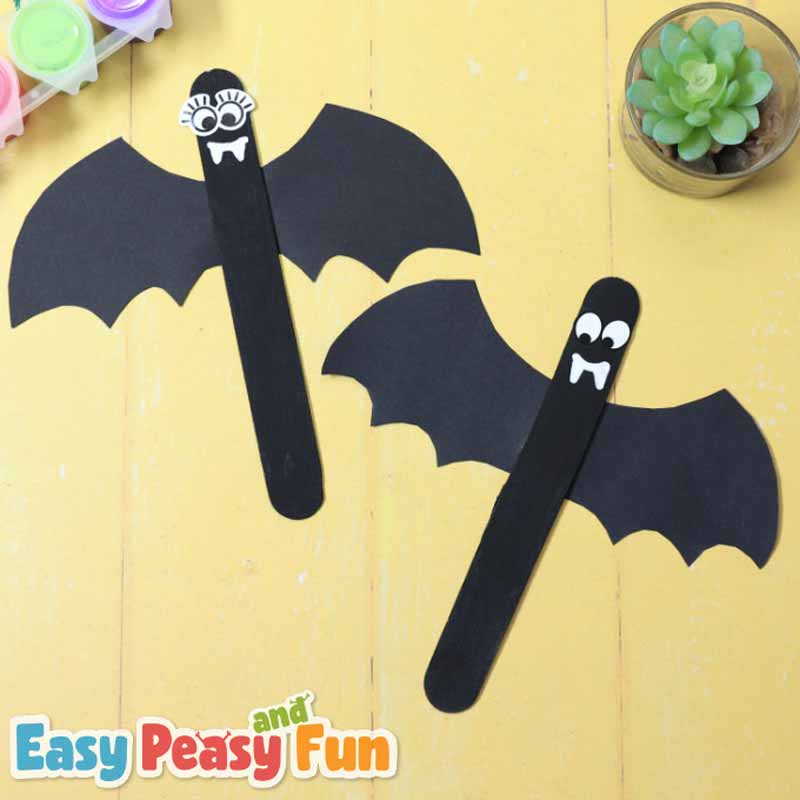 a group of black popsicle sticks with eyes and a couple of black bats