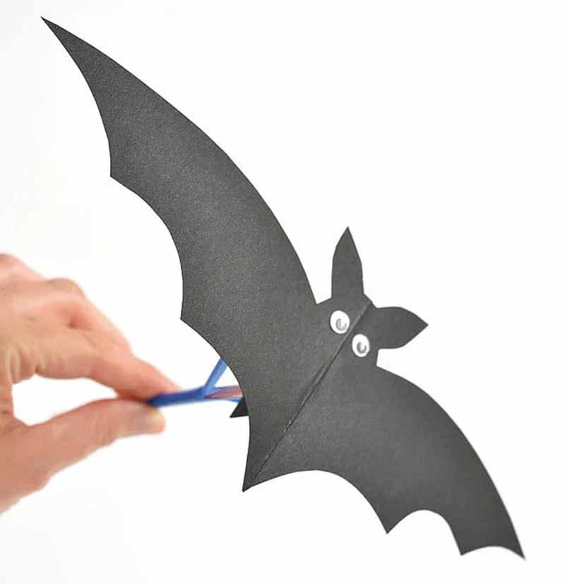 a hand holding a paper bat