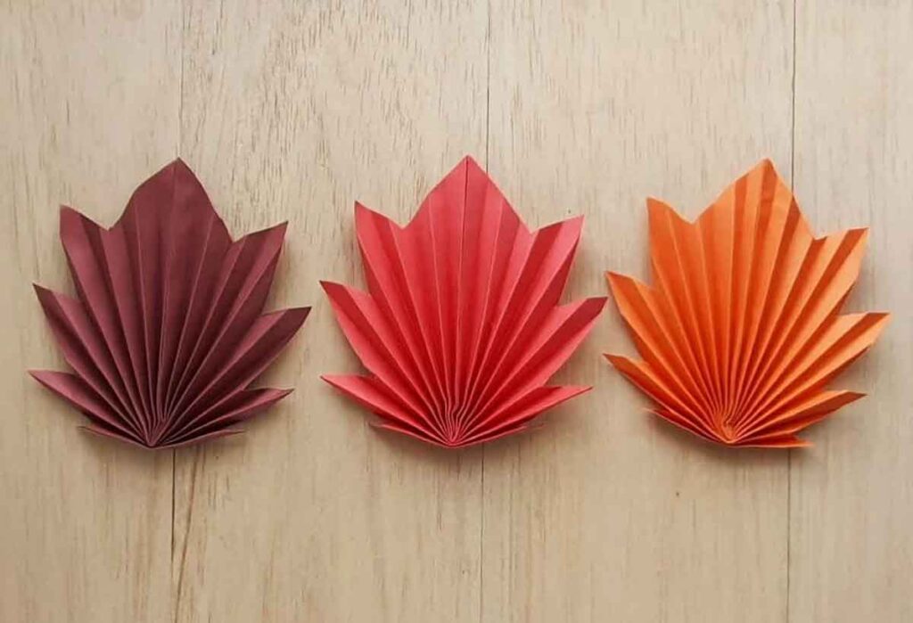 3 folded paper leaves in brown, red, and gold