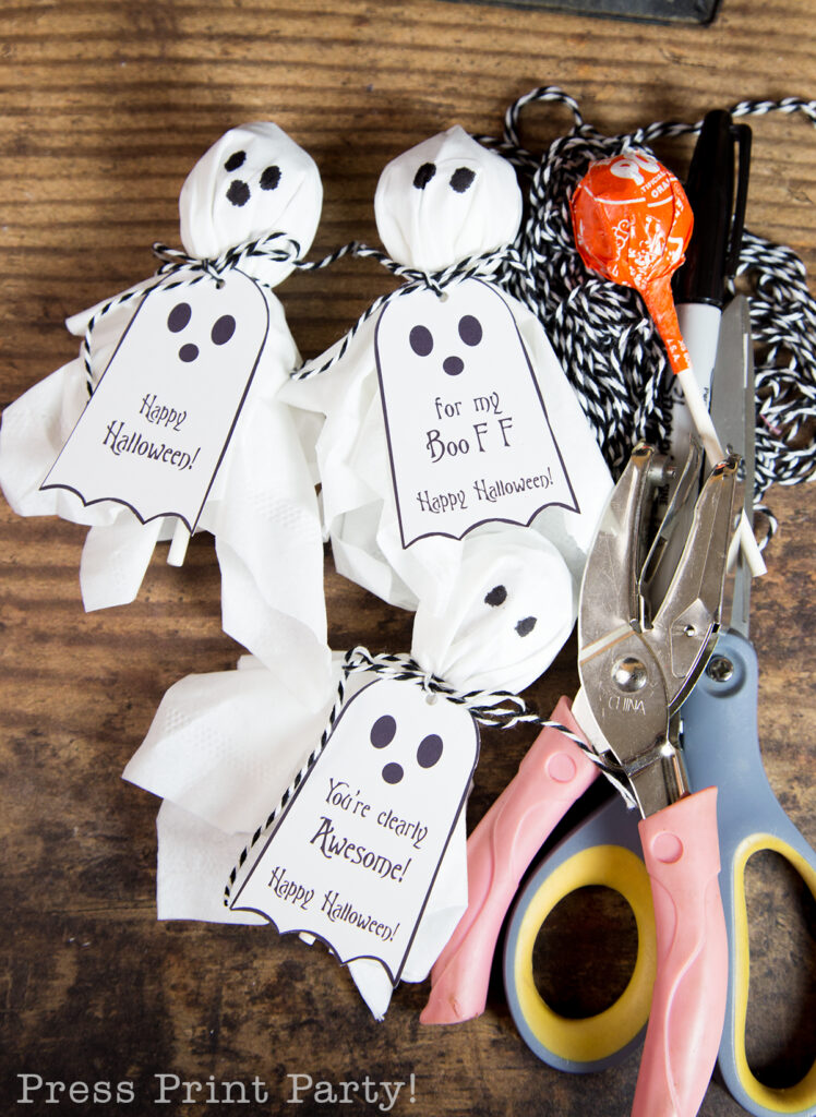 ghost lollipops with twine, scissor, hole puncher, and a lollipop
