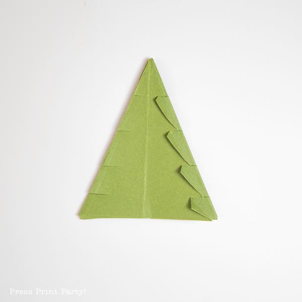 A folded paper Christmas tree crafted in origami style graces a pristine white background, showcasing its intricate folds and creases.