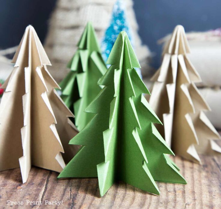 A collection of folded paper Christmas trees in green and brown shades are displayed on a wooden surface. These intricately crafted trees are skillfully layered, creating a festive, crafty scene.