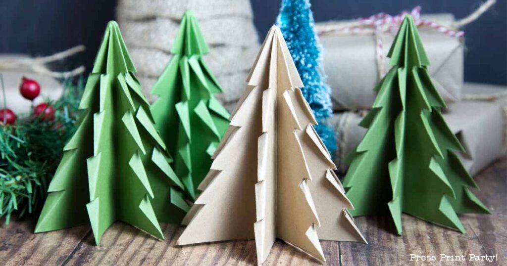 A cluster of folded paper Christmas trees in green and brown graces a wooden surface, with a softly blurred background showcasing wrapped gifts and vibrant red berries.
