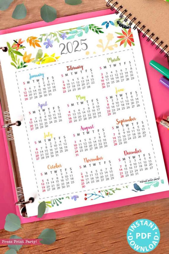 A vibrant 2025 calendar from our Watercolor Calendar Bundle for bullet journals or binders is set on a spiral notebook, decorated with leaves and pens. Each month is elegantly framed with floral borders, providing timeless beauty. A blue "Instant Download PDF" badge graces the corner, much like our 2025 calendar printable files for early planners.
