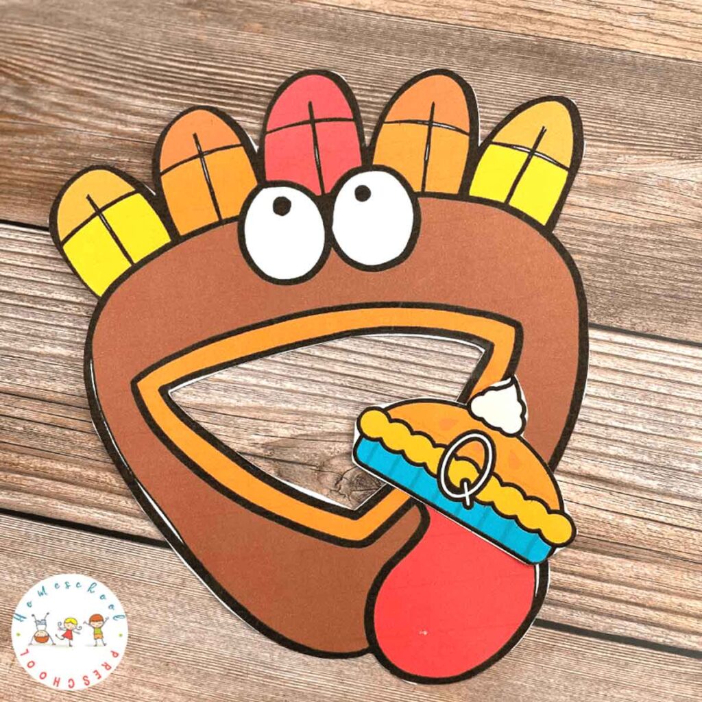 A cartoon turkey with colorful feathers looks excitedly at a pie with a dollop of whipped cream. The pie has the letter "Q" on it. The background is a wooden surface.