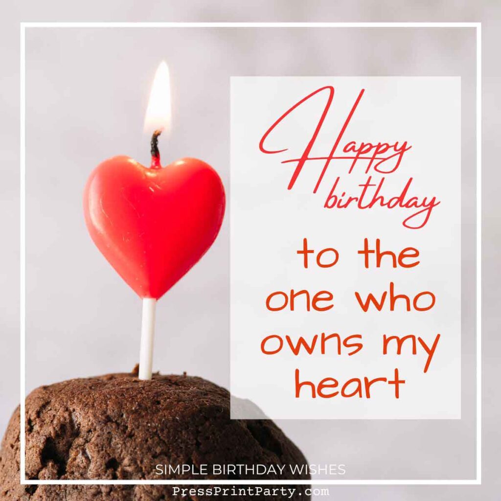 A lit red heart-shaped candle on a chocolate cupcake. Text reads "Happy Birthday to the one who owns my heart" in decorative script, encapsulating simple birthday wishes. The white background adds emphasis to the heartfelt candle and message.