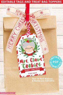 A brown paper bag adorned with a red and white "Merry Christmas" ribbon, featuring the Mrs. Claus Bakery Christmas Treat Bag Topper & Tag. The tag showcases a cartoon Mrs. Claus and the text "Mrs. Claus Cookies," and includes editable text for personalization.