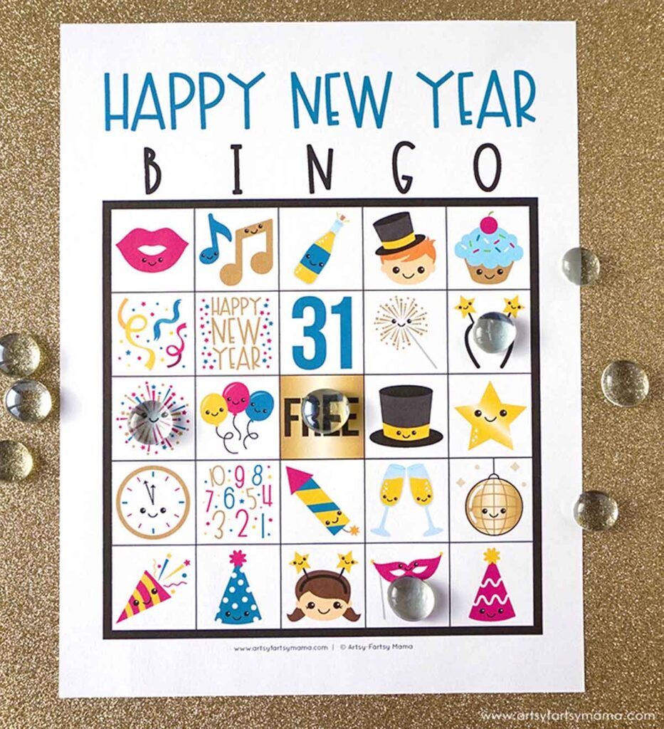 A bingo card titled "Happy New Year Bingo" features festive illustrations like musical notes, fireworks, a top hat, champagne glasses, and a clock. Some squares are marked with clear glass tokens. The card is placed on a gold glitter background. new year's printable games