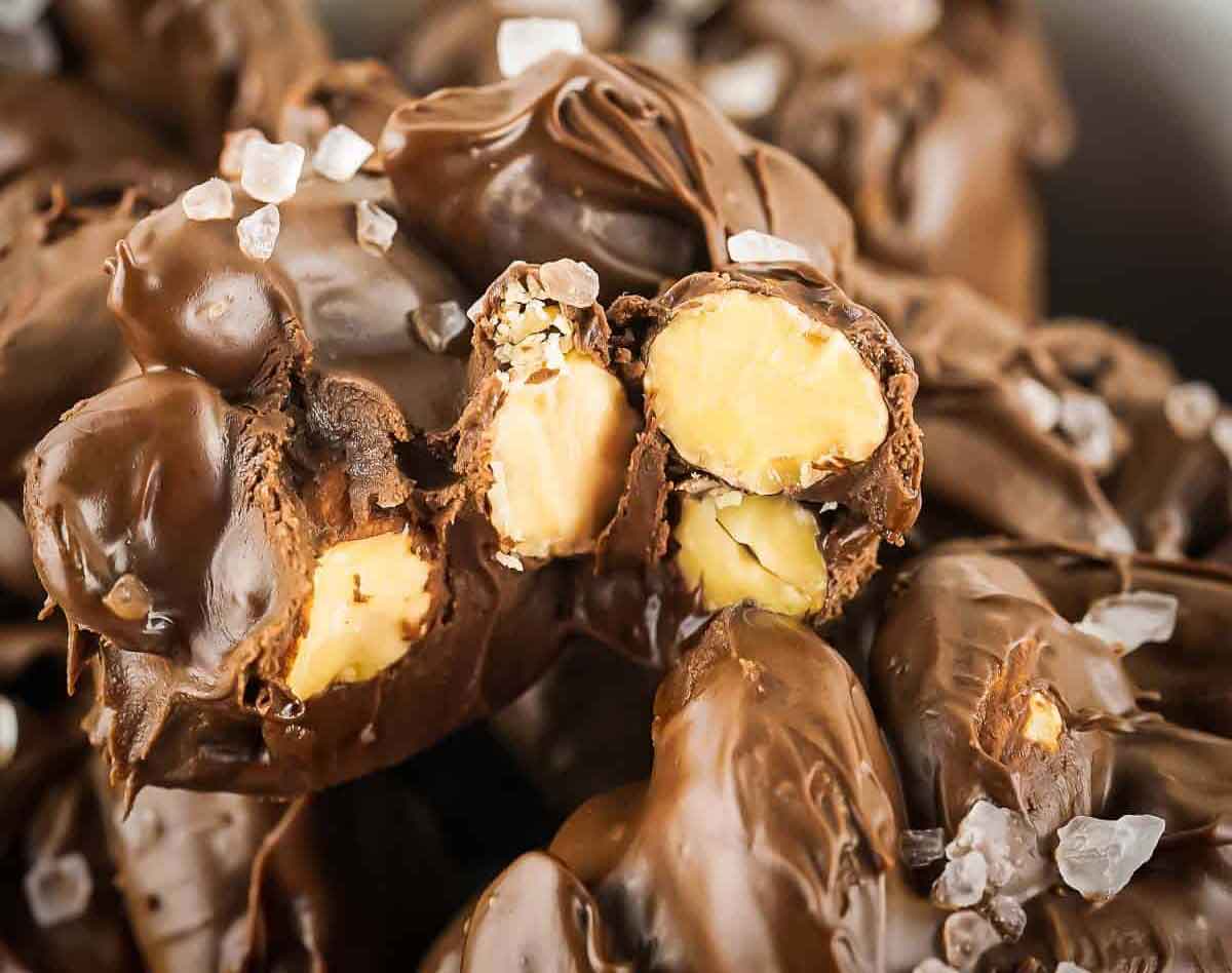 Close-up of chocolate-covered nuts sprinkled with coarse salt, perfect as healthy Valentine snacks for the classroom. The glossy chocolate and revealing nut cluster create a tempting sight, while the salt adds texture and contrast to the smooth treat.