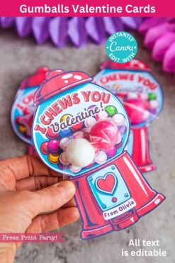 A hand displays the template (Copy) (Copy) Valentine card, featuring a gumball machine design with pink and white gumballs and 