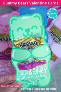 A hand holds a green bear-shaped Valentine card with Haribo gummies inside, reading 
